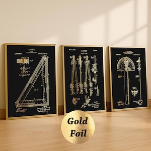 Puede incluir: Tres cuadros de pared con ilustraciones de patentes técnicas en lámina de oro sobre fondo negro. Las láminas muestran herramientas de dibujo técnico, incluyendo una escuadra, un compás y un transportador con texto y números de patente.