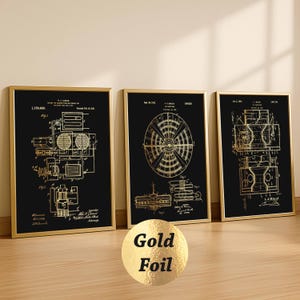 May include: Three rectangular wall art prints in thin gold frames. Each print features a black background with gold foil technical patent diagrams and text. The left print shows mechanical schematics, the center a circular component, and the right a cross-section view. A gold circular sticker with the text Gold Foil is in the foreground.