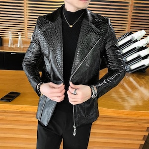 May include: A black leather jacket with a zip fastening and a snakeskin pattern. The jacket has a stand-up collar and long sleeves.