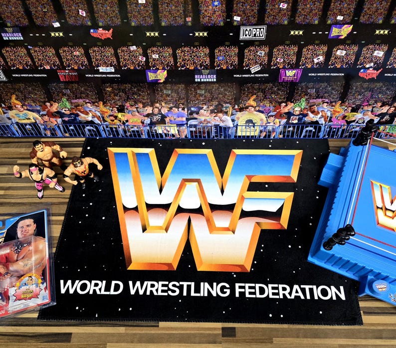 May include: A black mat with the World Wrestling Federation logo in gold, orange, and white, and the text "WORLD WRESTLING FEDERATION". A blue wrestling ring and action figures are also visible.