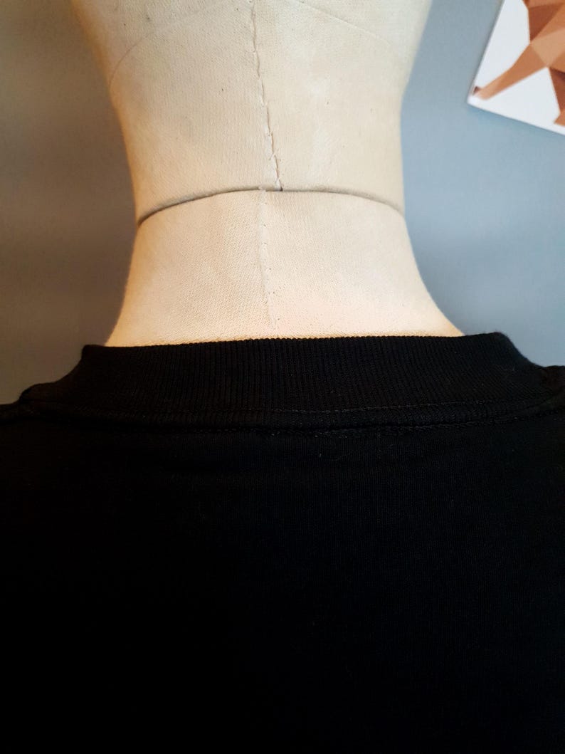 Puede incluir: Camiseta negra con cuello de canal&eacute;.