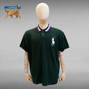 May include: Dark green polo shirt with a white embroidered logo of a person on a horse. The collar has white and purple stripes. The shirt is displayed on a mannequin.