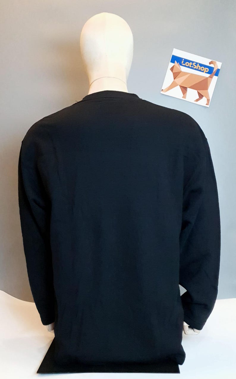 Puede incluir: Una camisa negra de manga larga en un maniqu&iacute;. La camisa tiene cuello redondo y est&aacute; hecha de una tela suave y c&oacute;moda.