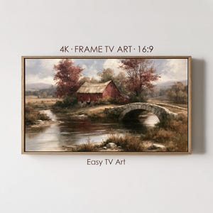 May include: A framed landscape painting featuring a red barn beside a stone arch bridge over a calm river, surrounded by autumn-toned trees and fields. The text 4K FRAME TV ART 16:9 and Easy TV Art is printed above and below the artwork.