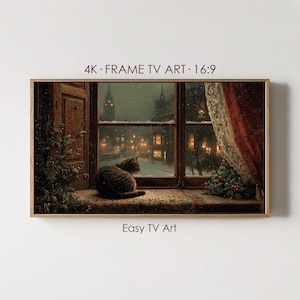 以下が含まれることがあります： 4K FRAME TV ART 16:9およびEasy TV Artと記された長方形のデジタルアートプリント。雪の降る夜の街を窓辺から眺めるキジトラ猫が描かれています。右側には赤いカーテンが掛かり、窓枠には植物が飾られています。