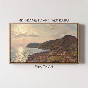 May include: A framed landscape painting of a coastal scene with a sunset. The artwork features a rocky shoreline, rolling hills, and a calm sea reflecting the sunlight. The text "4K • FRAME TV ART • 16:9 RATIO" and "Easy TV Art" are visible.