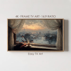 May include: A framed digital art piece depicting a winter landscape viewed through a window. The artwork shows a snowy town at sunset, with a cup of tea on the windowsill. The text "4K • FRAME TV ART • 16:9 RATIO" and "Easy TV Art" are visible.