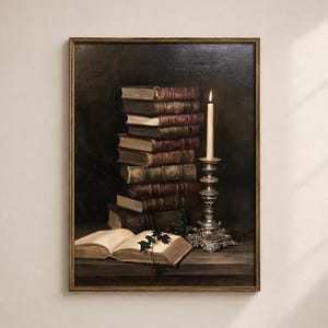 May include: A framed wall art print depicting a stack of weathered, leather-bound books in shades of brown and tan next to a tall, ornate silver candlestick holding a lit white candle. An open book with a small sprig of dark green ivy lies in front.