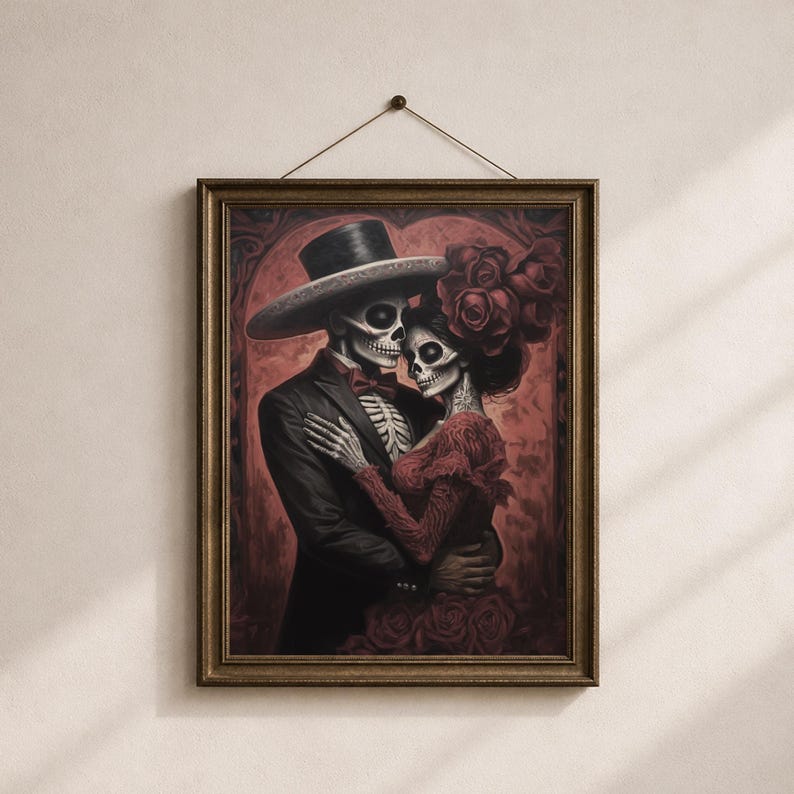 May include: A framed print depicting a skeletal couple in an embrace, dressed in formal wear. The man is in a black suit and a wide-brimmed hat, and the woman wears a red dress with roses. The artwork has a dark, romantic theme, with a red background.