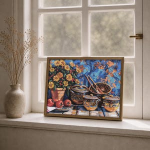 May include: A framed still life painting featuring a terracotta pot of yellow flowers, ceramic bowls, and red apples. The painting has a gold frame and is set against a blue and orange background. The scene is on a windowsill.