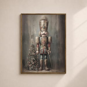 Könnte beinhalten: Gerahmter Kunstdruck eines Vintage-Nussknackersoldaten mit hohem Hut, Schnurrbart und dekorativer Uniform. Links vom Nussknacker befindet sich ein kleiner Weihnachtsbaum. Das Kunstwerk hat eine gedämpfte Farbpalette mit Gold- und Rotakzenten.