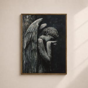 May include: A framed artwork depicting a grayscale sculpture of a sorrowful angel. The angel, with detailed feathered wings, is leaning against a textured surface, head bowed. The artwork is set against a dark background, framed in a gold-toned border.