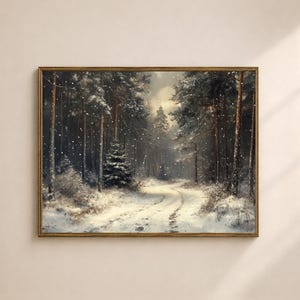 Op de afbeelding: Een ingelijst schilderij van een winterlandschap, met een besneeuwd bos met hoge bomen en een kronkelend pad. Het kunstwerk gebruikt een palet van wit, bruin en grijs, met vallende sneeuwvlokken die diepte toevoegen. Het schilderij zit in een goudkleurige lijst.