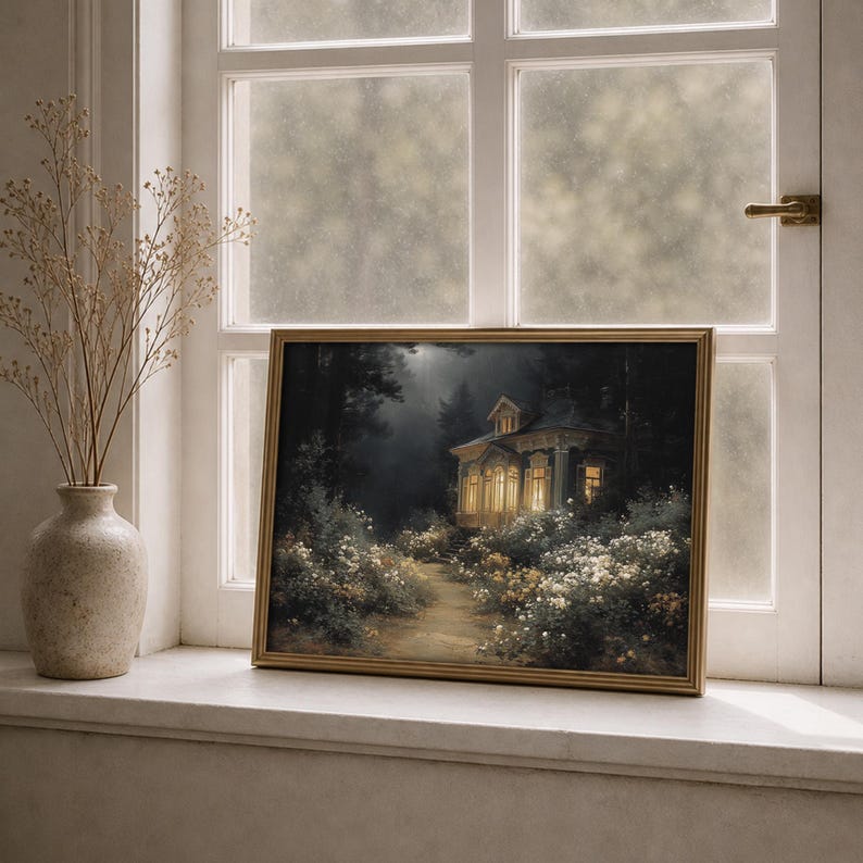 May include: A framed landscape painting of a building with lit windows in a forest setting. The artwork features a path leading to the building, surrounded by white and yellow flowers. The frame is gold, and the painting is displayed on a windowsill.