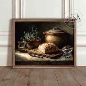 May include: A framed still life painting featuring a loaf of bread on a wooden cutting board with a knife, a clay pot with herbs, a glass of liquid, and a large pot. The painting has a dark, moody aesthetic.