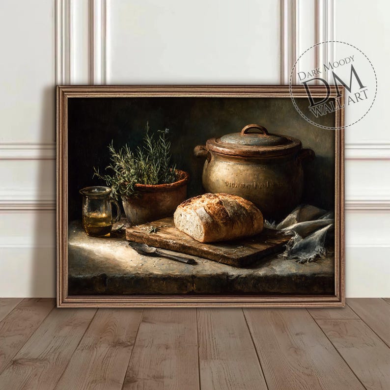 Op de afbeelding: Een ingelijst stilleven schilderij met een brood op een houten snijplank met een mes, een kleipot met kruiden, een glas vloeistof en een grote pot. Het schilderij heeft een donkere, melancholische uitstraling.
