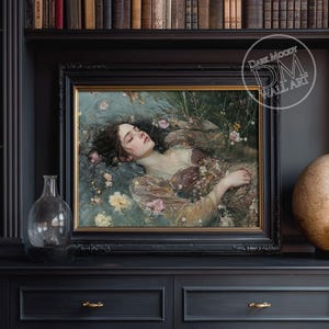 May include: A framed artwork featuring a woman floating in water, surrounded by flowers. The painting has a gold frame and is displayed on a dark, ornate cabinet. A glass vase and a decorative globe are also visible.
