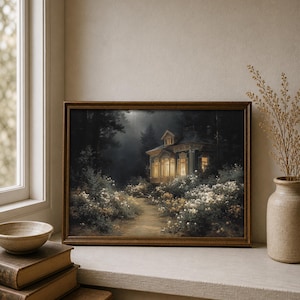 May include: A framed art print depicts a cottage illuminated by warm light, nestled in a dark forest. A path leads to the cottage, surrounded by white flowers. The artwork is in a brown wooden frame.
