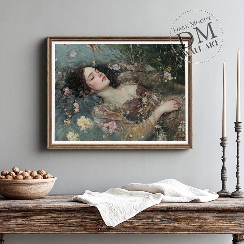 May include: A framed art print featuring a woman floating in water, surrounded by flowers. The artwork has a vintage aesthetic with soft colors and a dreamy quality. The frame is brown, and the print is labeled "Dark Moody Wall Art".