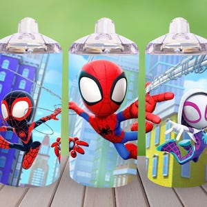 May include: Three clear plastic cups with handles, each featuring a different Spider-Man character. The cups have a blue and yellow background with city buildings and web designs. The characters are Spider-Man, Miles Morales, and Spider-Gwen.