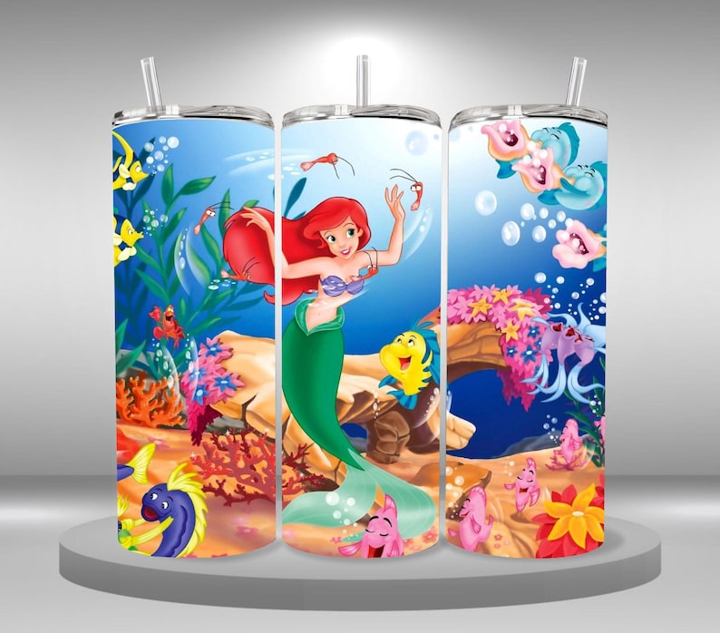 May include: Three stainless steel tumblers with a colorful design featuring Ariel, the Little Mermaid, swimming in the ocean with other sea creatures. The tumblers are decorated with bubbles, coral, and seaweed.