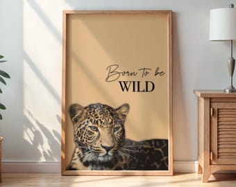Può includere: Un poster beige con un'illustrazione in bianco e nero di un leopardo. Il testo "Born to be WILD" è scritto in corsivo nero.