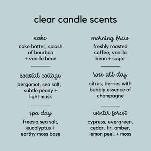 May include: A light blue informational sign titled clear candle scents listing six fragrance options: cake, morning brew, coastal cottage, ros&eacute; all day, spa day, and winter forest, each with a detailed breakdown of their specific aromatic notes.