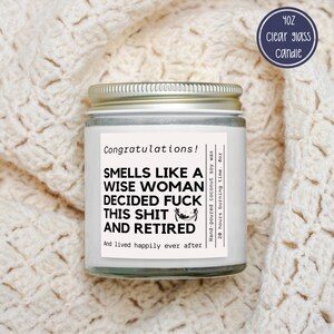 May include: A clear glass candle jar with a silver lid, featuring a label with the text "Smells Like A Wise Woman Decided Fuck This Shit And Retired." The candle is 4oz and made with hand-poured coconut soy wax.