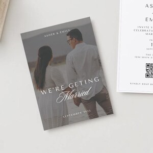 May include: A wedding invitation with a photo of a couple in front of a desert landscape. The text reads "Asher & Emily We're Getting Married September 2025". The invitation also includes the date, time, and location of the wedding.