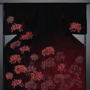 Pode incluir: Um quimono preto e vermelho com um design degradê apresentando flores vermelhas e contornos brancos. As flores são dispostas em um padrão espalhado por todo o tecido.