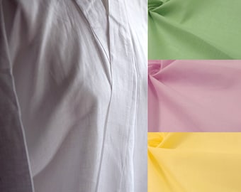 May include: A white linen shirt with a mandarin collar and a long, flowing silhouette. The shirt is shown with five fabric swatches in different colours: light blue, green, pink, yellow, and blue.