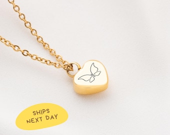 May include: Gold-colored heart-shaped pendant necklace with a butterfly design. The pendant is suspended from a delicate chain. The image also includes a yellow oval with the text "SHIPS NEXT DAY".