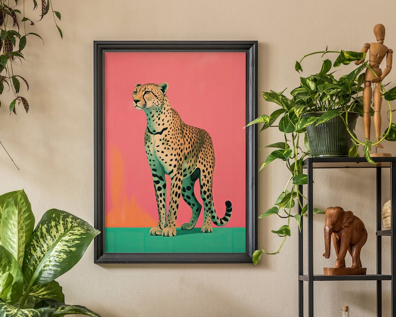 K&ouml;nnte beinhalten: Ein gerahmter Druck eines Geparden, der auf einem gr&uuml;nen Hintergrund steht. Der Gepard blickt nach rechts und hat einen rosa Hintergrund hinter sich.