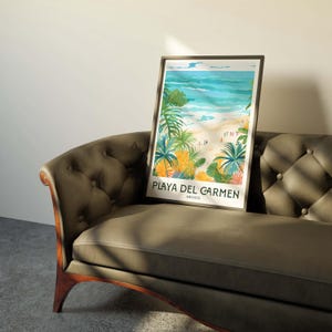 May include: A framed poster featuring a colourful illustration of a beach scene with palm trees and turquoise water. The text "PLAYA DEL CARMEN MEXICO" is printed at the bottom of the poster.