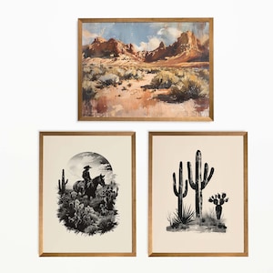 Op de afbeelding: Drie ingelijste kunstdrukken met een woestijnthema. De bovenste print is een landschapsschilderij van een woestijnsc&egrave;ne met bergen. De onderste print links is een zwart-wit illustratie van een cowboy op een paard. De onderste print rechts is een zwart-wit cactus illustratie.