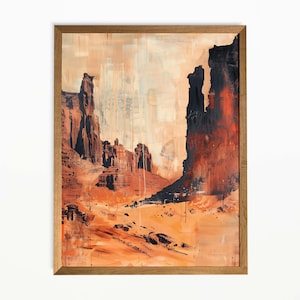 Op de afbeelding: Abstracte kunstprint van een woestijnlandschap, met tinten oranje, bruin en zwart. Het kunstwerk is ingelijst in een natuurlijke houten lijst. De schildering toont torenhoge rotsformaties en een uitgestrekt, open landschap.