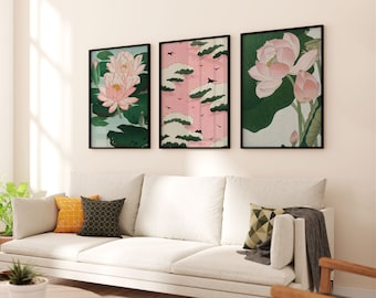 May include: Three framed prints of Japanese-style artwork featuring pink lotus flowers and green leaves. The prints are hung on a white wall above a white couch with pillows.