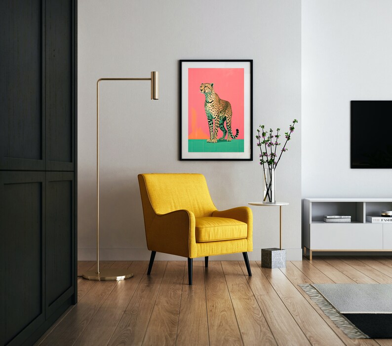 K&ouml;nnte beinhalten: Ein gelber Sessel steht in einem Wohnzimmer mit einem gerahmten Druck eines Geparden auf rosa Hintergrund. Der Druck h&auml;ngt an einer wei&szlig;en Wand. Eine goldene Stehlampe steht neben dem Sessel. Ein kleiner Tisch mit einer Vase mit Blumen steht im Vordergrund.