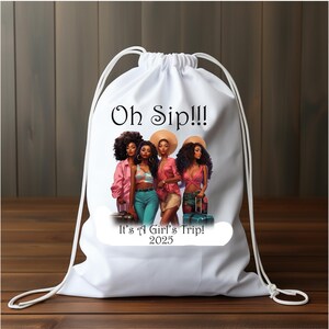 May include: White drawstring bag with a graphic of four women with suitcases and the text "Oh Sip!!! It's A Girl's Trip! 2025"