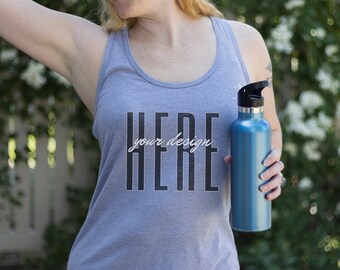May include: A heather gray tank top with the text "HERE your design HERE" printed on the front. The person is holding a blue water bottle.