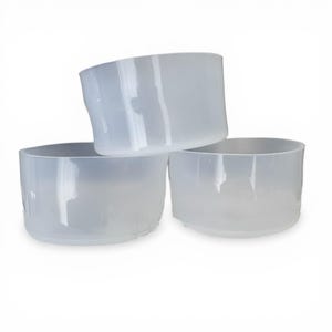 May include: Three translucent, cylindrical containers stacked together. The containers are made of a frosted, opaque material. The containers have a simple, minimalist design, with a slightly curved shape. The containers are empty and appear to be made of plastic.