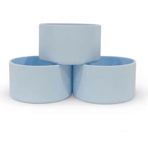 May include: Three light blue silicone protective boots for tumblers arranged in a pyramid formation. Each boot features a smooth, cylindrical shape with a flat base and open top, designed to fit the bottom of a standard beverage container.