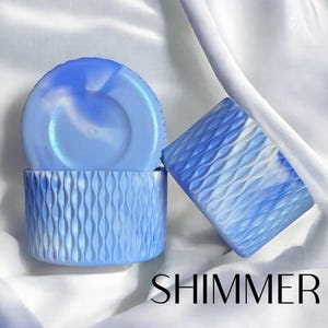 May include: Two light blue containers with a wavy pattern and a matching lid. The containers are on a white background with the word "SHIMMER" in black text at the bottom. The containers have a marbled blue and white design.