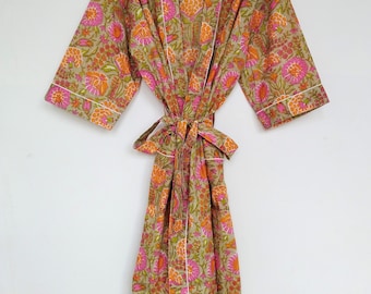 May include: A floral print robe in shades of olive green, pink, and orange, with white trim. The robe is tied at the waist with a matching fabric belt. The robe is hanging on a black hanger.