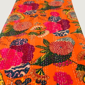 Peut inclure: Couverture kantha orange avec un motif floral dans des tons de rose, violet, bleu et vert. La couverture est cousue &agrave; la main avec du fil blanc.