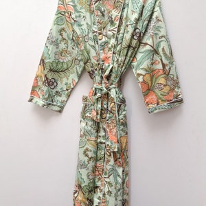 May include: A green floral print robe with a white trim. The robe has a tie belt and two pockets.