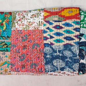 May include: A patchwork quilt with a variety of colorful floral and geometric patterns. The quilt features squares of different fabrics, stitched together with visible thread. The colors include teal, red, white, and blue, creating a vibrant and textured appearance.