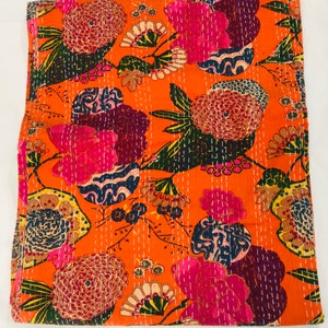 Peut inclure: Couverture kantha orange avec un motif floral dans des tons de rose, bleu, vert et marron. La couverture est en coton et est cousue &agrave; la main.
