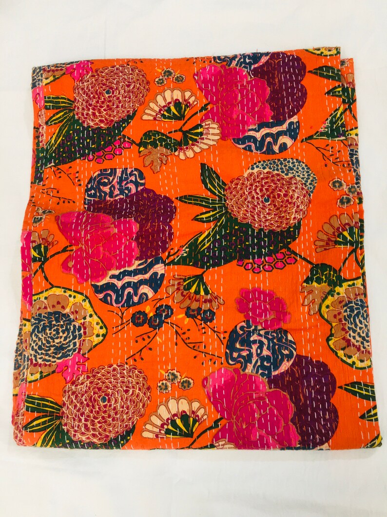 Peut inclure: Couverture kantha orange avec un motif floral dans des tons de rose, bleu, vert et marron. La couverture est en coton et est cousue &agrave; la main.