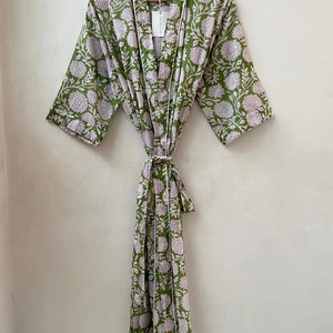 May include: A green and white floral print robe with a tie waist. The robe has a white trim around the edges.
